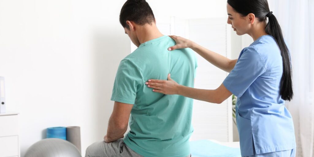 doctor examining male patients back